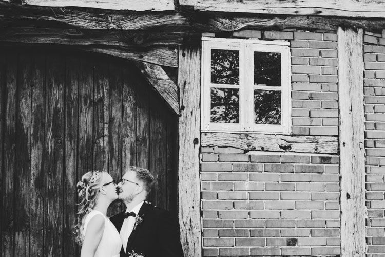 Wedding couple kissing in front of old house